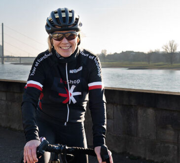 EuroShop-Director Elke Moebius auf ihrem Rennrad am Rhein