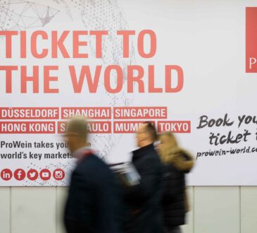 Besuchende der ProWein 2023 vor einem „Ticket to the World“-Schild als Header für einen Artikel über Wein und Japan