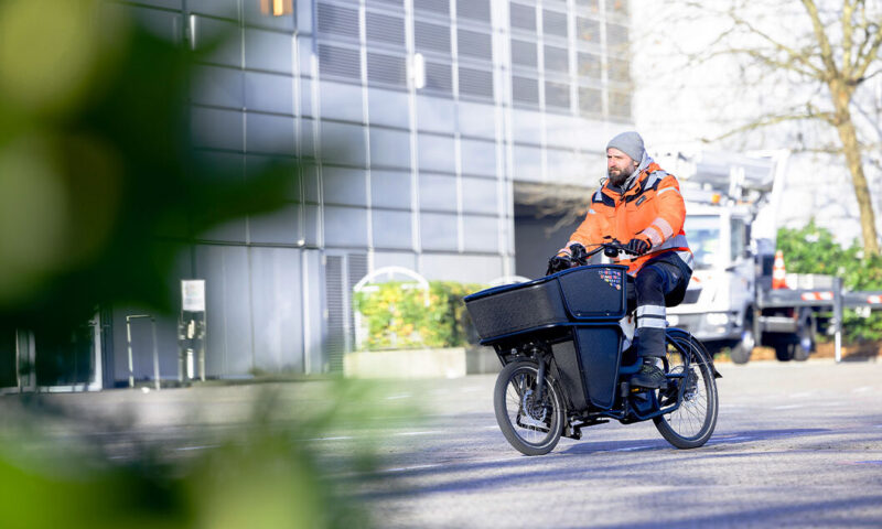 Das Bild zeigt das Lastenrad der Messe Düsseldorf, gefahren von einem Kollegen