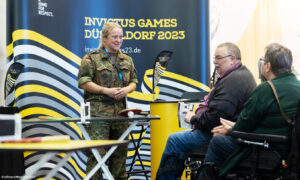 Besucher informieren sich bei einer Dame in Uniform über die Invictus Games 2023