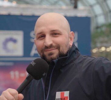 Messe-Mitarbeiter Apostolos Hatzigiannidis mit einem Mikrofon in der Hand auf der Medizintechnik-Messe MEDICA